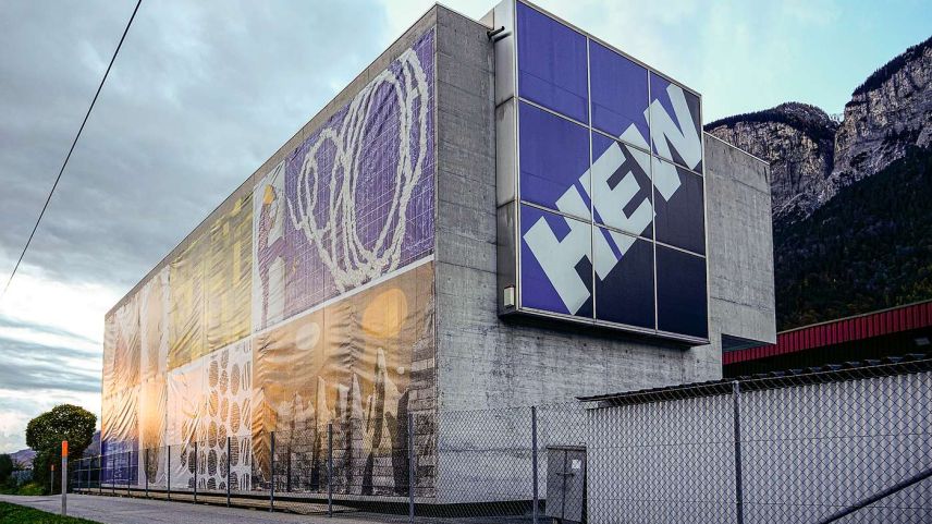 Auf knapp 300  m2 vereint eine Blache am Verwaltungssitz der HEW AG in Domat Ems/Felsberg die Arbeiten von  sieben Bündner Kunstschaffenden für das Firmenjubiläum in Form einer Collage. Foto: Jon Duschletta
