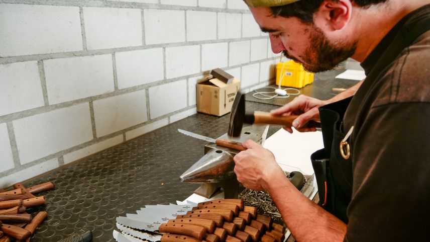 Sein Bruder Marco befestigt danach den Nussbaumgriff mit drei Stahlnieten an der Klinge, schleift diese bündig und schleift auch den Griff fertig.