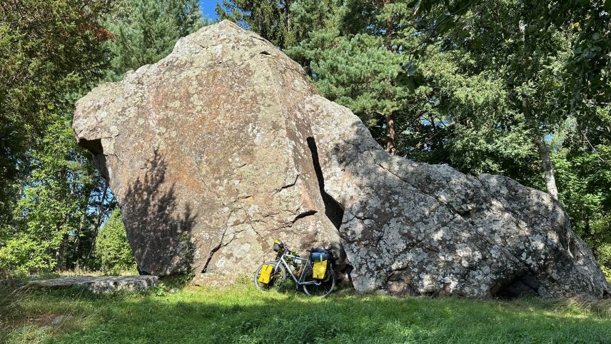 Das voll bepackte Travelbike von Daniel Müller im Grössenvergleich mit einem der riesigen Findlinge im Norden Estlands. Foto: Daniel Müller