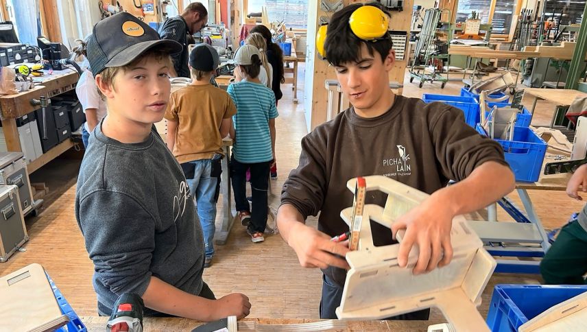 In der Schreinerei Pichalain in Fuldera lernen die Kinder, wie aus einzelnen Holzteilen Gehstelzen entstehen. Foto: PHGR