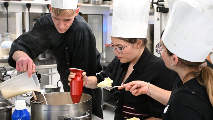Koch Julian Kasper unterstützt die Schülerinnen bei der Zubereitung der Vorspeise und des Desserts. Foto: Fabia Niggli