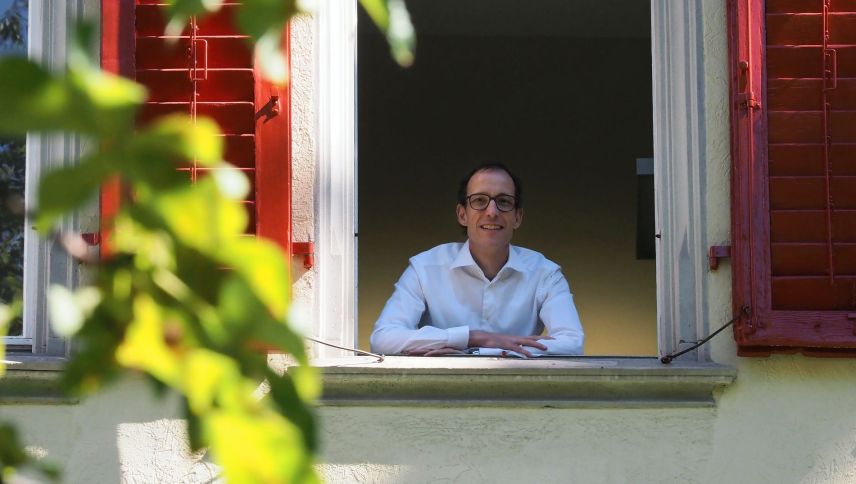Andreas Gabriel a la fanestra da la Chasa Rumantscha e da seis büro dal secretariat general. Daspö trais mais occupa el quel post pro l’organisaziun da tet rumantscha, la Lia Rumantscha. fotografia: David Truttmann
