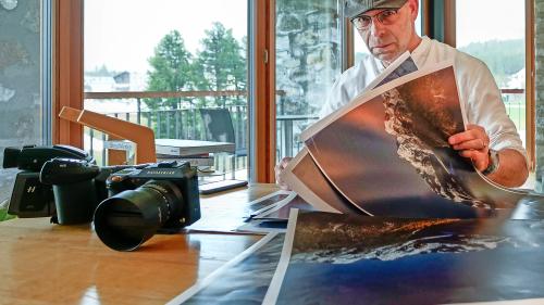 Der Fotograf, Gestalter und Kommunikationsfachmann Simon Walther sichtet in seinem «Basecamp» in Maloja
Vordrucke zum neuen Bildband «MondLichtbilder», welcher am 5. Juni erscheint. Foto: Jon Duschletta