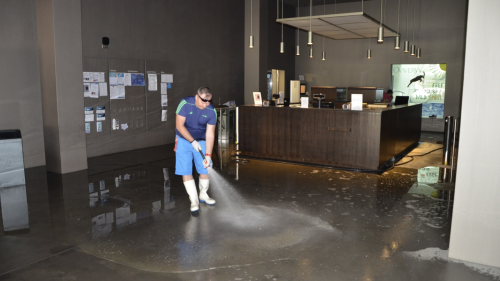 Reinigungsarbeiten im St. Moritzer Sportzentrum Ovaverva: Wasser drang in das Untergeschoss mit dem Eingang vor. Es hinterliess eine feine Sandschicht, die am Montag entfernt werden musste. Foto: Christian Gartmann