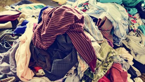 Nahaufnahme eines Kleiderhaufens von unterschiedlich gebrauchten Kleidungsstücken. Foto: shutterstock.com/nito